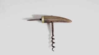 IRON CORKSCREW WITH CARVED WOOD HANDLE AND BRASS FERRULE.